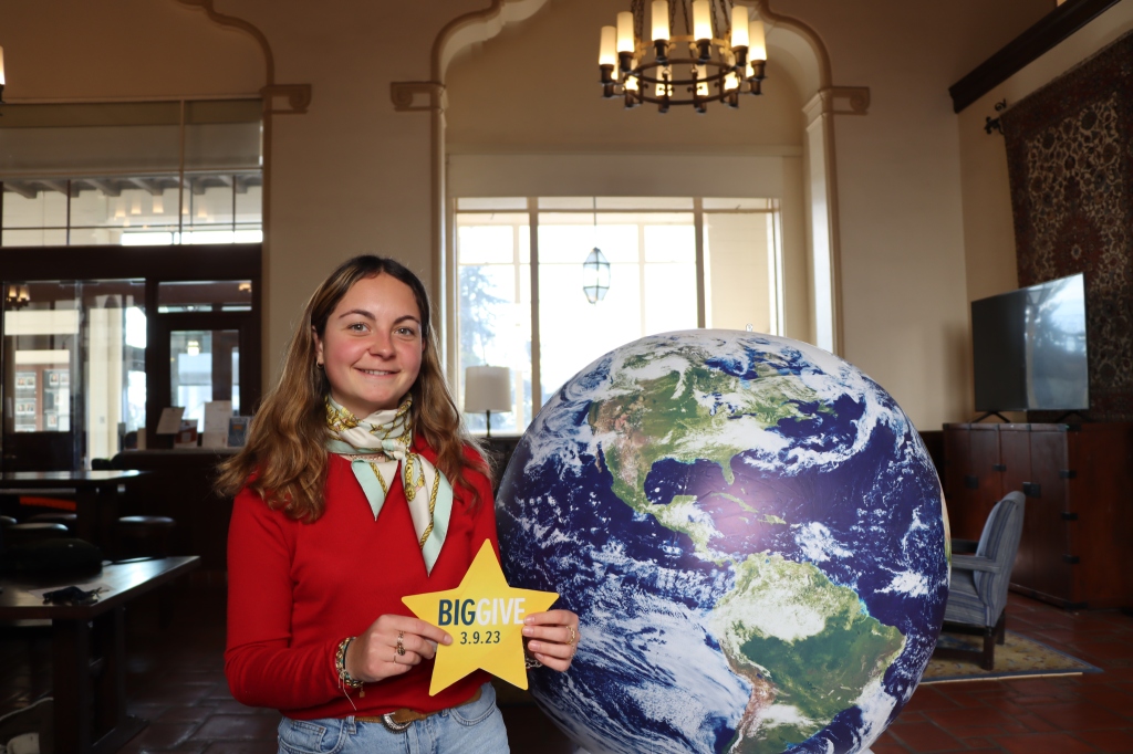 Resident holding Big Give star by our globe