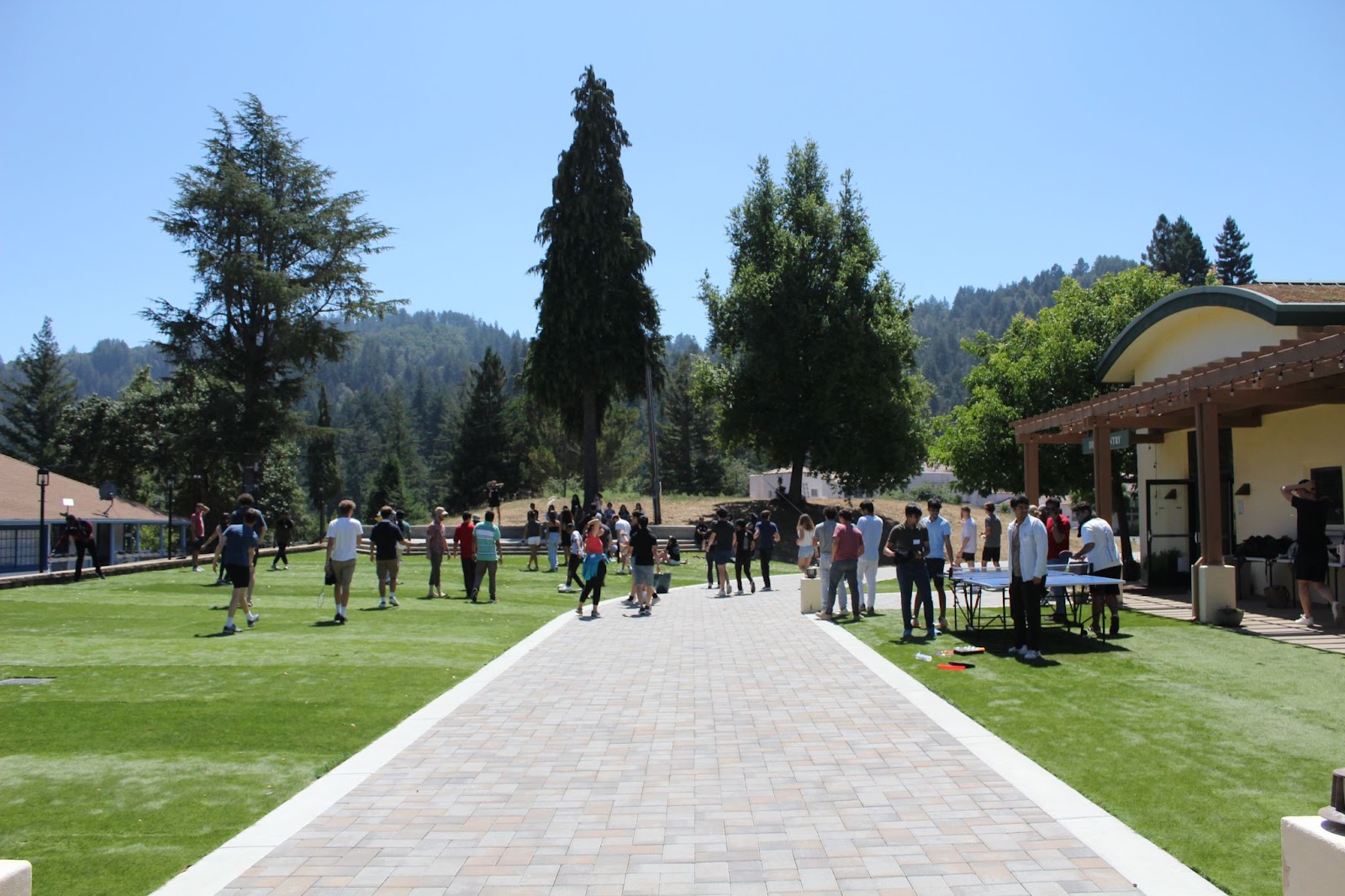 A lot of residents are gathered outside on the lawn at the retreat. They are exploring the area or engaging in some recreational activity.