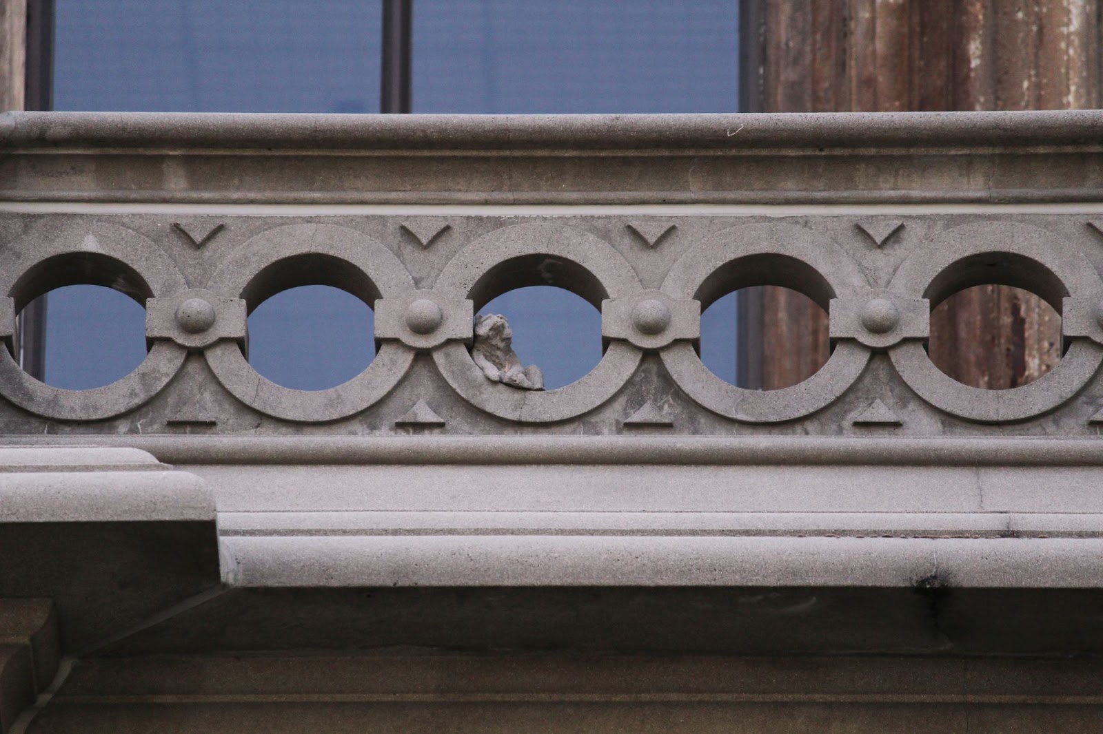 A zoomed in image of the balcony railings, where the smallest bear is visible in one of the rungs. 
