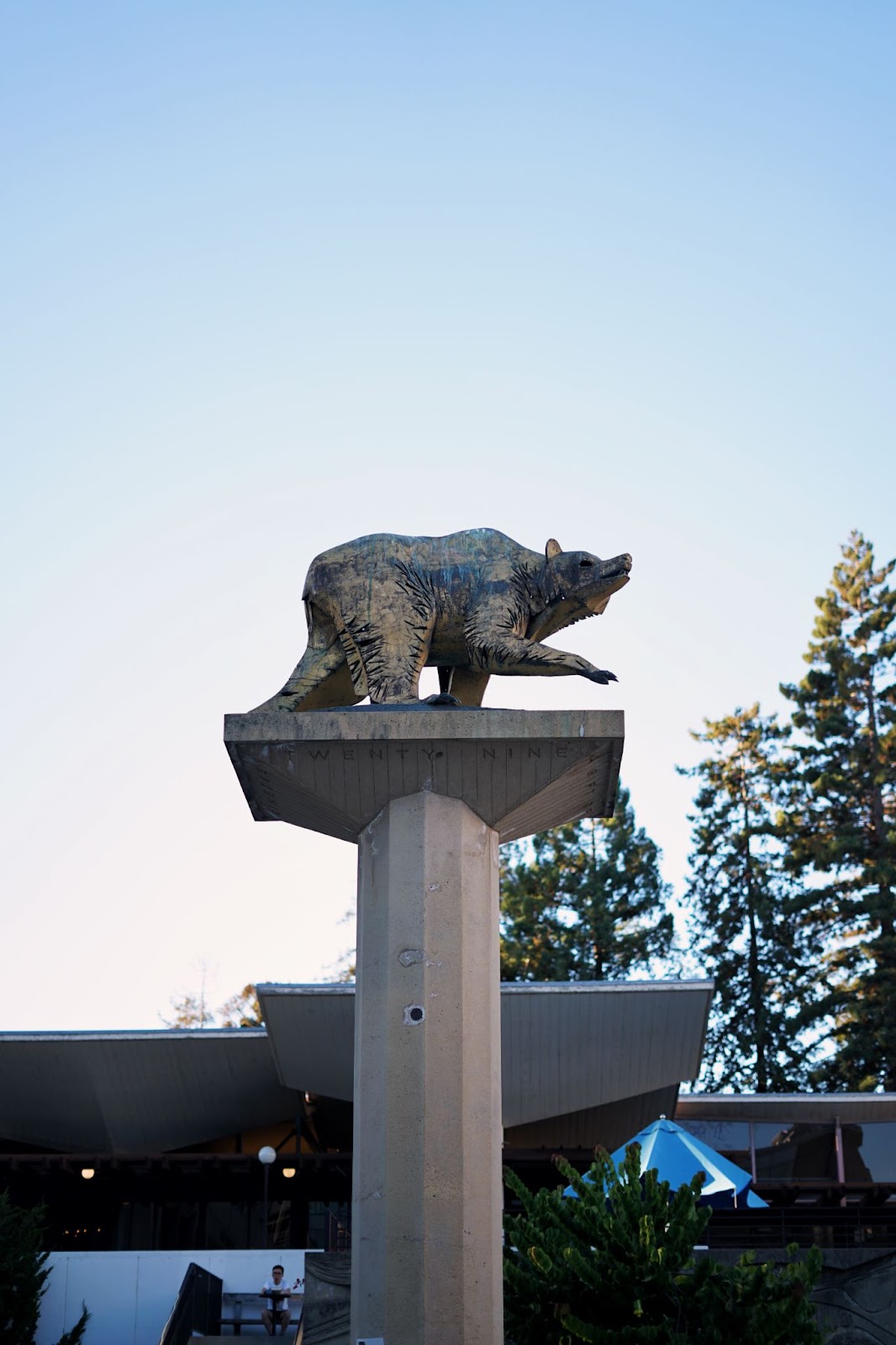 A statue of a bear walking atop a pillar. 