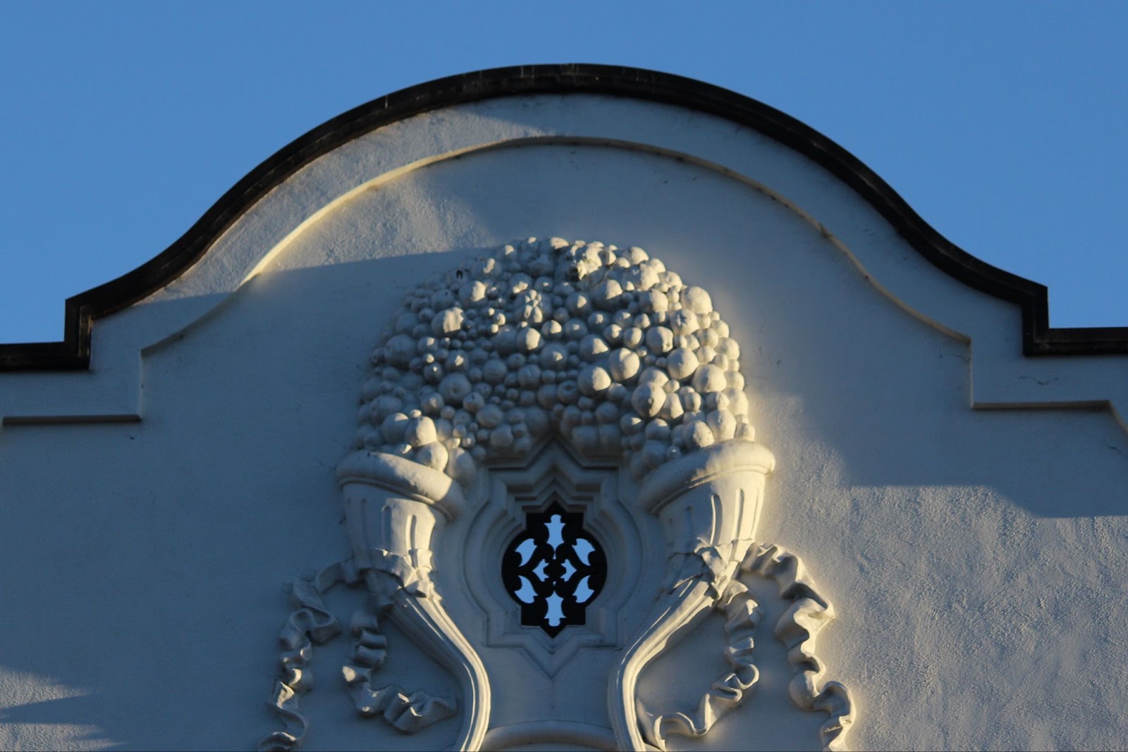 A bubbly relief embellishment above a window of the Granada building. There is a small bear head at the center of the top of the embellishment. 
