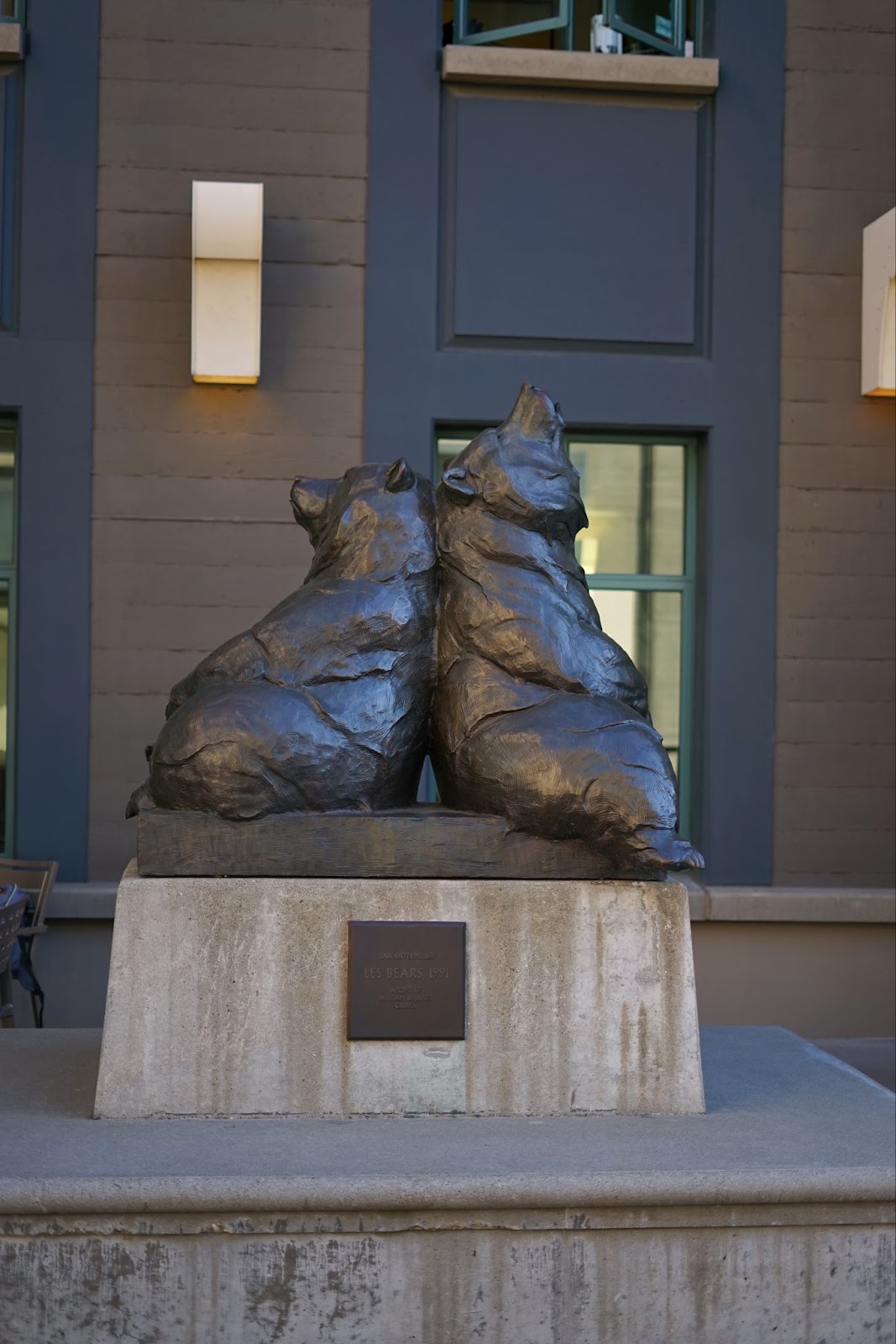 A statue of two bears, back to back, facing up, and slumped on each other. 
