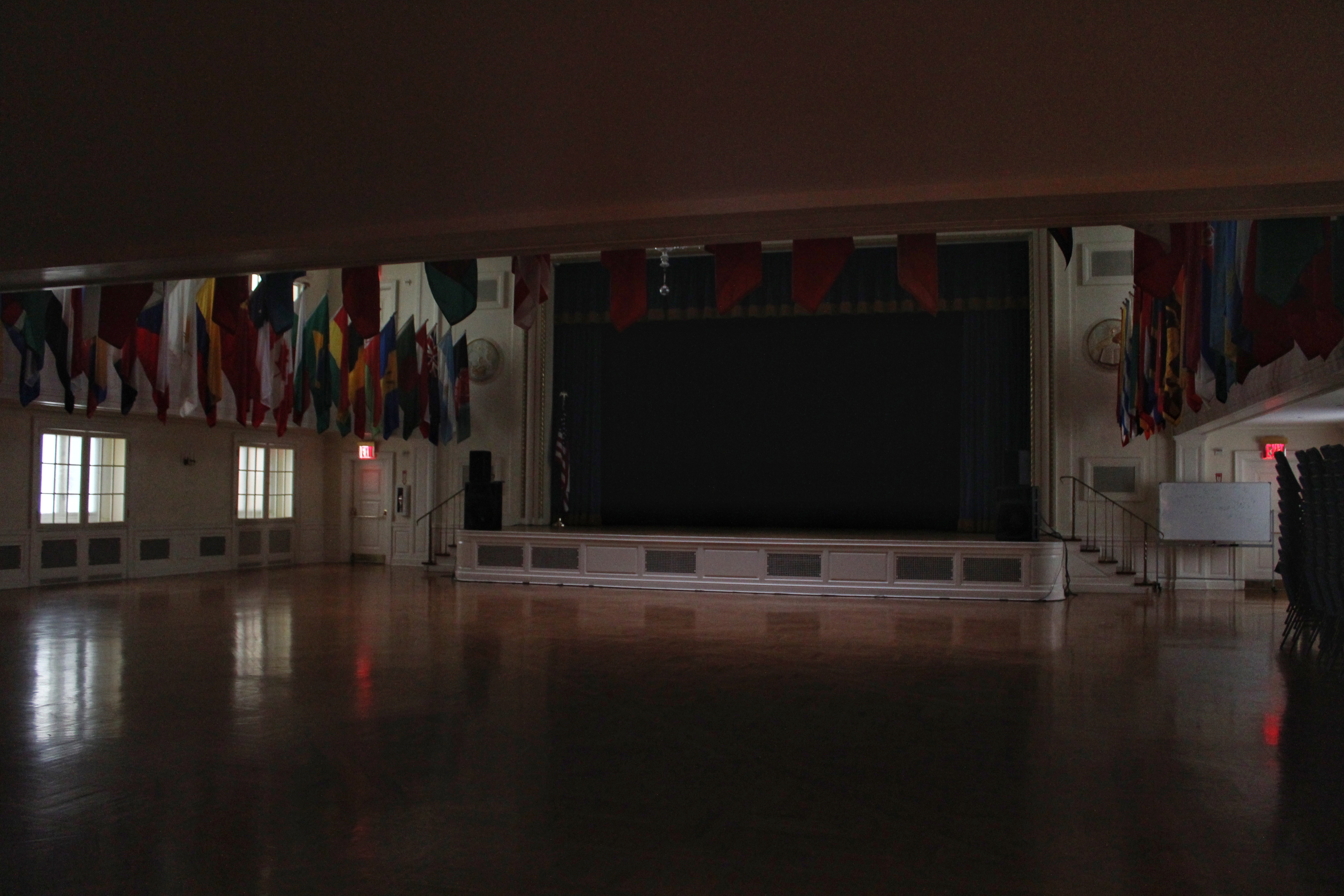 An auditorium with many national flags on all four sides. 