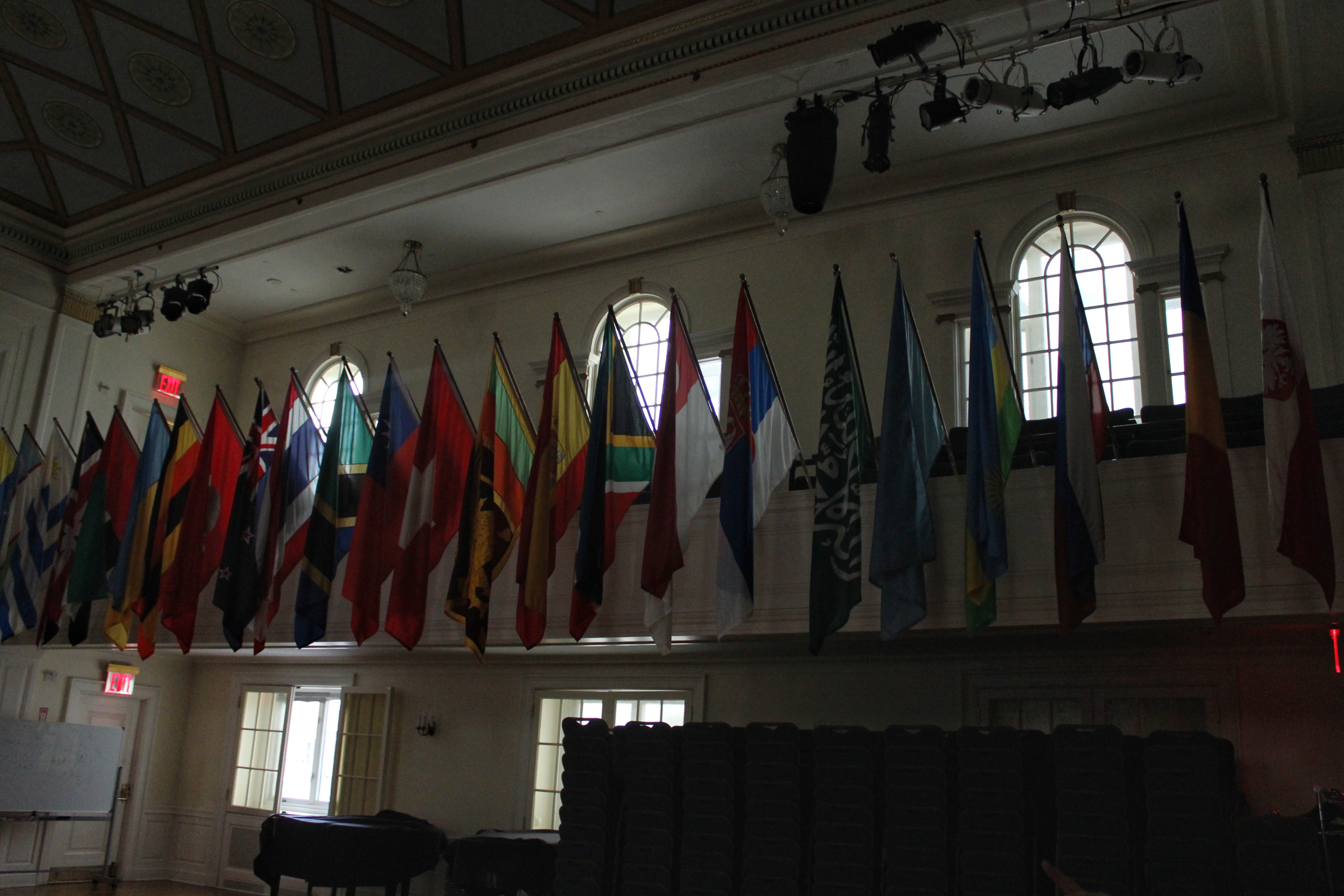 An auditorium with many national flags on all four sides. 
