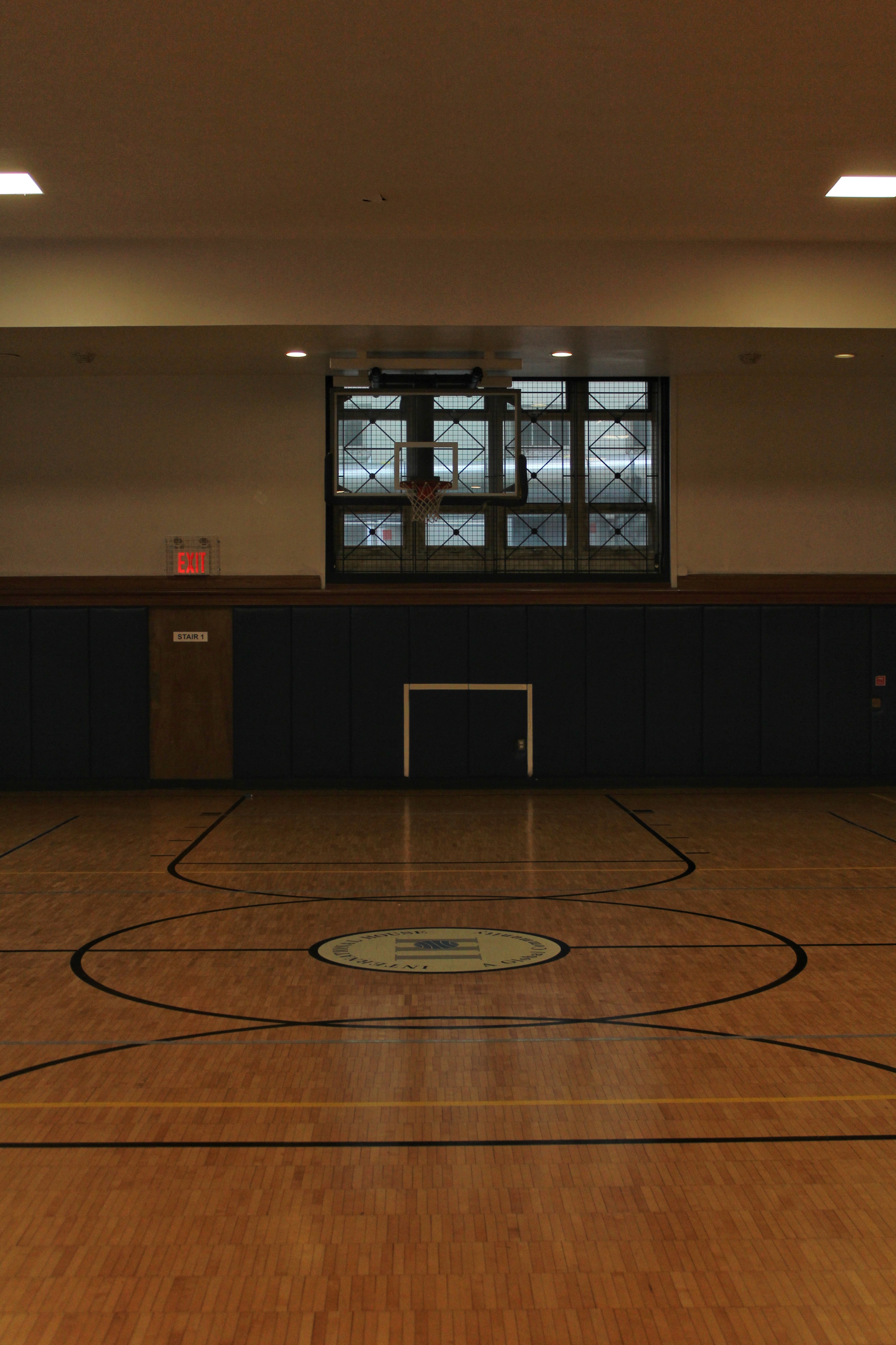 A hardwood basketball court with a football (soccer) goal cut-out in the wall. 